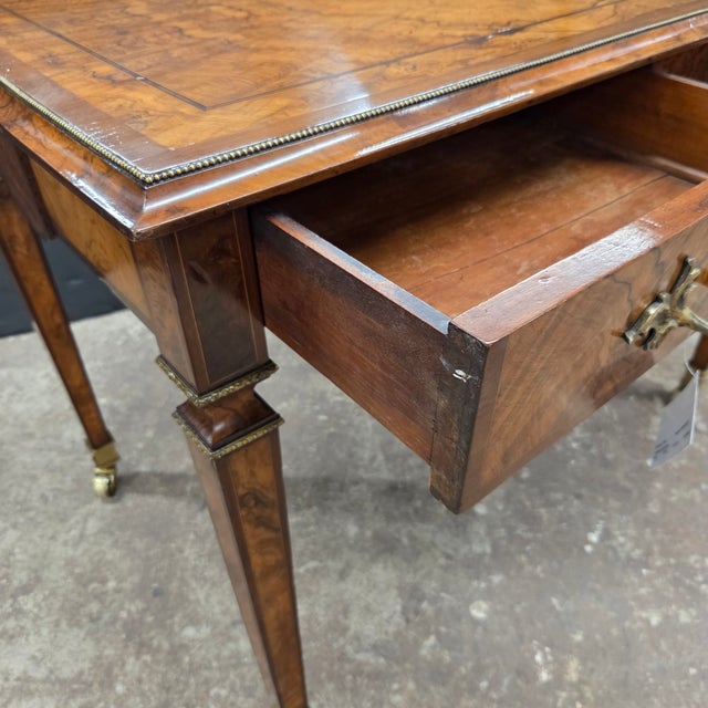 This Regency walnut and rosewood inlaid center table with 2 drawers, brass beading, ornate brass handles, and square...