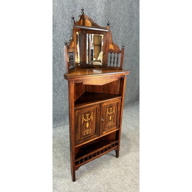 This 19th Century inlaid rosewood corner étagère features an elegant mirrored back with spindled side galleries and a...