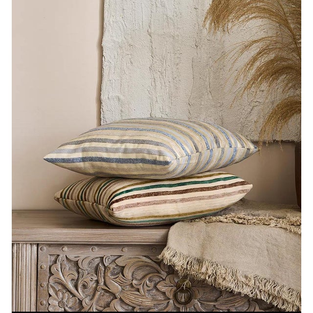 This square throw pillow features classic and serene vertical stripes in gray-blue and off-white, presenting a modern...