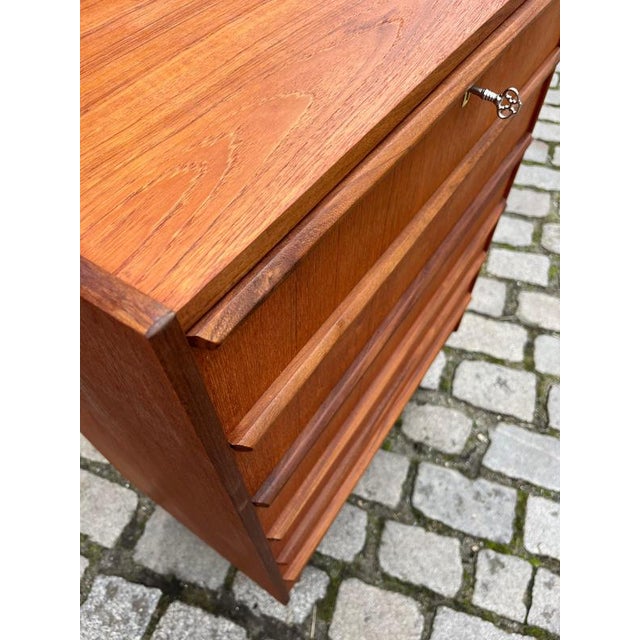 This teak chest of drawers from Denmark impresses with its clean, mid-century design and elegantly crafted, continuous...
