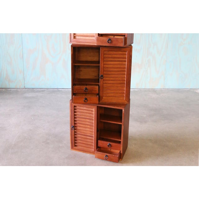 3 studio made walnut cabinets with doweled sliding doors that conceal open storage and double sided drawers. Can be wall...