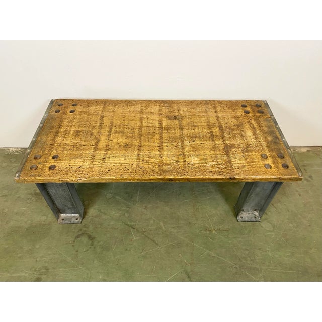Industrial coffee table. It features iron legs and old wooden plate with very nice patina. Weight 49 kg.