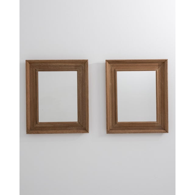 A pair of 19th century French wall mirrors in oak, slightly larger in scale and maintaining a structured and proportionate...