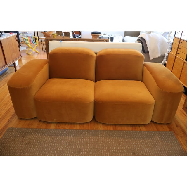 A four-piece modular sofa from Sarah Ellison's "Muse" collection for Ellison Studios, upholstered in warm cognac velvet....