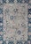 Oushak rug from Turkey with floral blossom all-over design rendered in gray, blue, ivory, and red tones. Keivan Woven Arts...