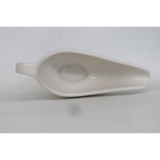 This beautiful footed Gravy Boat is made of Ceramic. This lovely cream colored ceramic piece was made by Hall China...