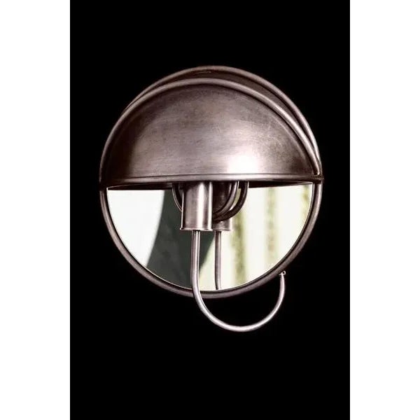 Cast brass sconce with mirror and tubed brass arm arriving into hooded upper section. Moderne style.