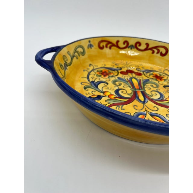Colorful handled dish with an Italian design painted in the center. The bright yellows, blues, reds and greens make this a...