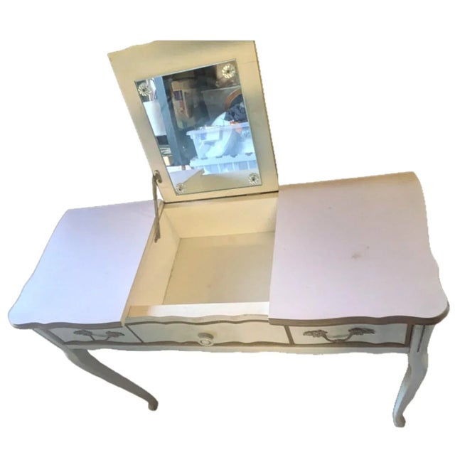 1970s vintage makeup dresser in a French Provincial style with a hideaway mirror at the center. The Makeup vanity is...