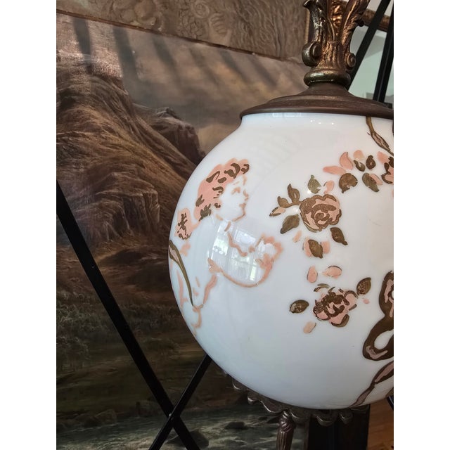 A rare and vintage original pre mid century hanging globe light fixture with floating putti decoration. Absolutely correct...