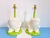 Big pair of creamy white whimsical smiling plaster frog lamps seated upright on lime green painted metal bases with raised...