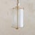 A 1950s Italian lacquered metal lantern pendant with a cylindrical silhouette. The ivory-toned frame descends from a...