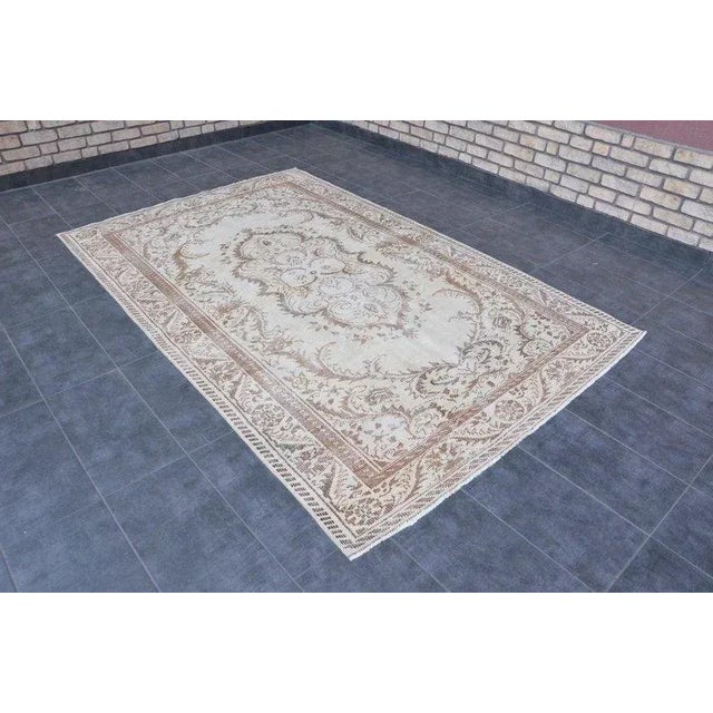 This is a vintage Turkish Oushak rug from the 1960s. The piece was hand-knotted.