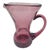A soft plum ghost in glass, this pitcher carries the hush of handwork and time. Its neck curves inward as if to listen,...