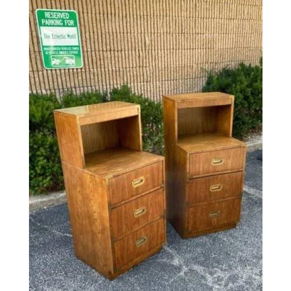 Featured for your careful consideration is a pair of very rare tall lighted campaign nightstands by Dixie. 3 drawer chests...