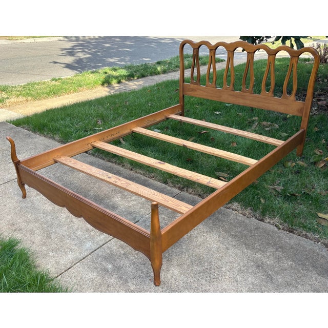Vintage French Provincial or French Country full-size bed frame. Features a carved headboard and cabriole legs on the...