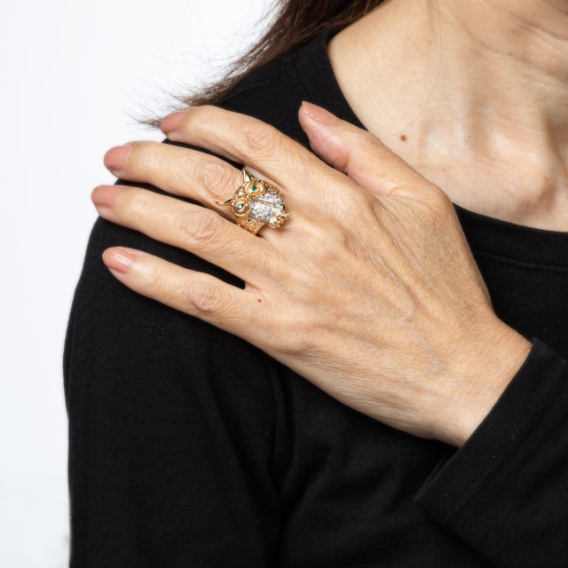Finley detailed owl ring set with diamonds and green emerald eyes, crafted in 14 karat yellow gold (circa 1970s). Single...