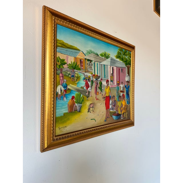 A stunning Haitian village scene by Louines Mentor, expertly captured in oil on canvas. The composition is filled with...