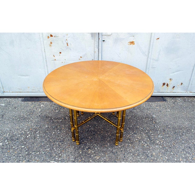 Table with a solid worked brass structure and a round wooden top. Italian production 1970s