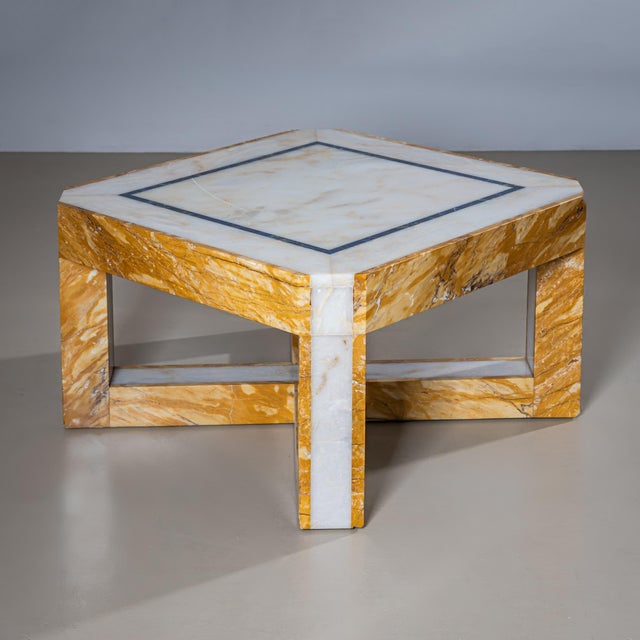 A pair of exceptional and heavy marble coffee tables. The square tops with chamfered corners are set on an X-shaped base....