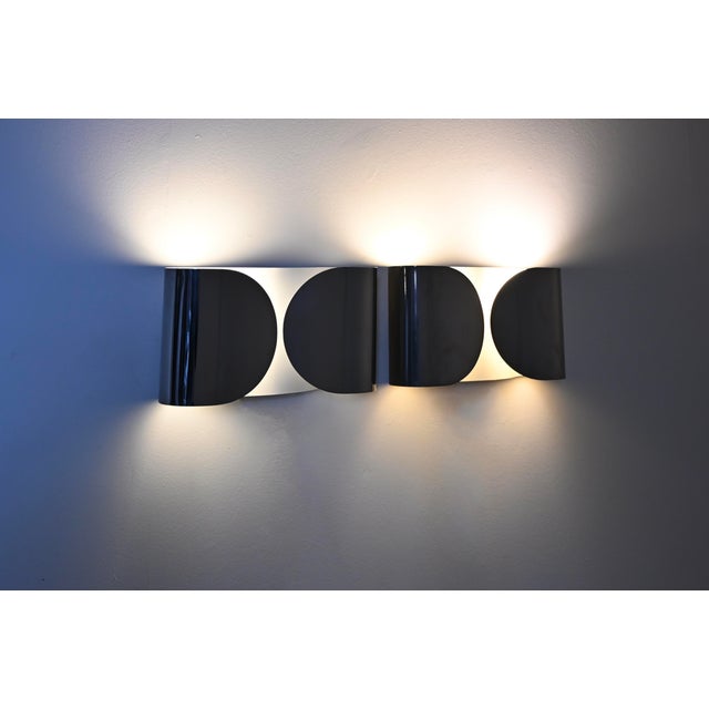 Pair of chrome-plated metal wall lights designed by Afra & Tobia Scarpa. Model: Foglio. Wear consistent with age and time....
