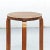 This stool from the 1960s features a wooden frame and brown leather upholstery.