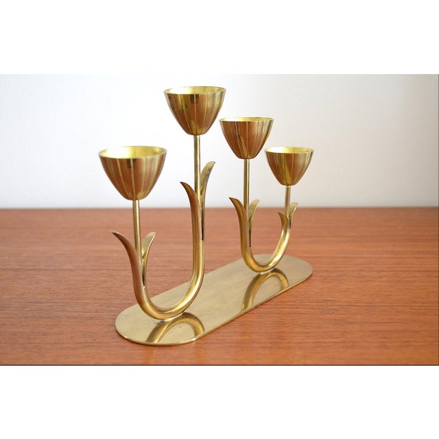 This four-armed brass candlestick was designed by Gunner Ander in the 1960s and manufactured for Ystad Metall in Sweden....