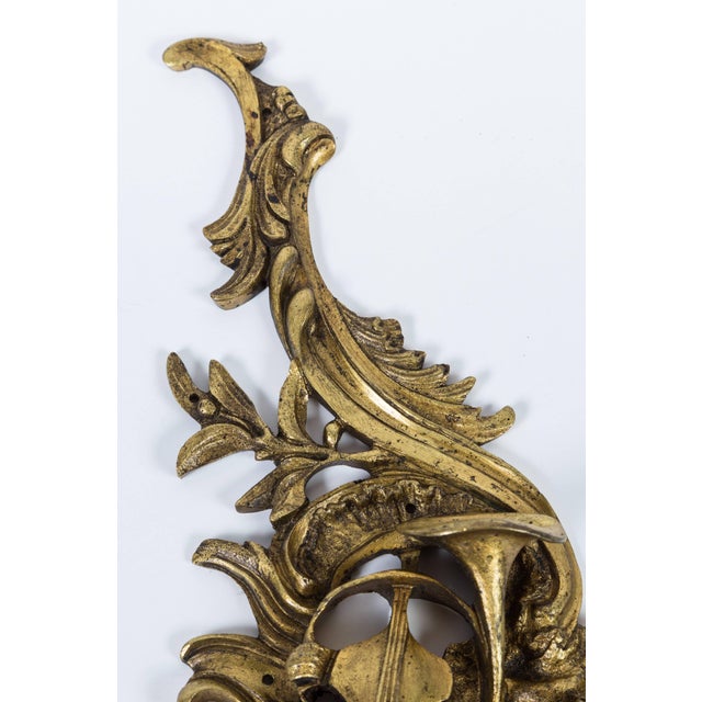 Heavy, ornate brass applique depicting musical instruments; originally used to decorate a piece of furniture, but will...