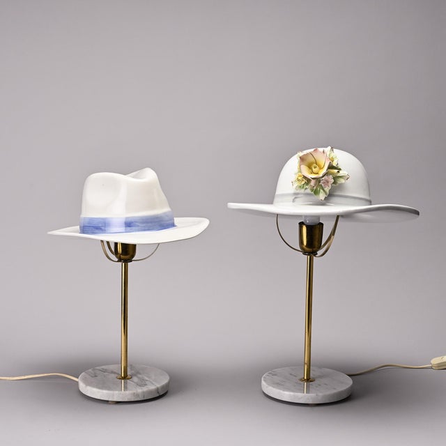 Pair of table lamps made in Italy in the 1970s. Each lamp rests on a circular white marble base surmounted by a gilt brass...