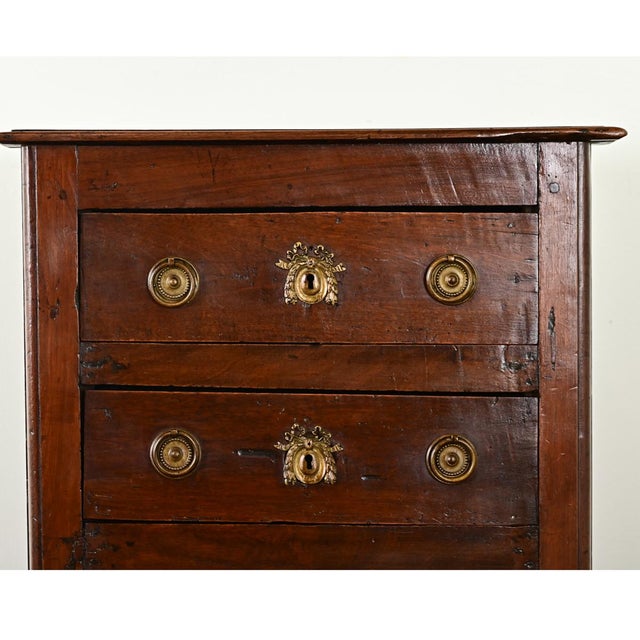 Dimensions: 32 ¾” H x 23 ½” W x 18 ¼” D A petite commode or chest of drawers from France, early 19th century, made from...