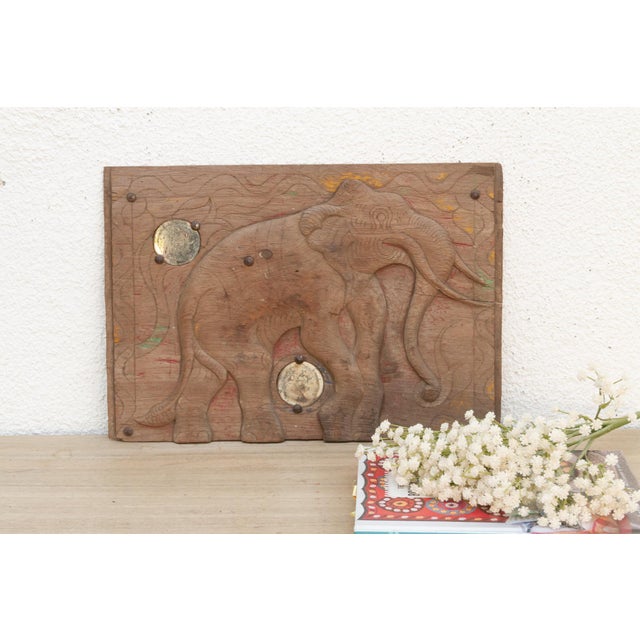 This carved wooden panel, depicting a powerful elephant, originate from Thailand and likely date to the mid-20th century...