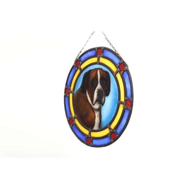 A vibrant Belgian Art Deco stained‑glass roundel from around 1900, centred with a lively portrait of a Boxer dog rendered...