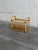 Vintage rattan magazine rack featuring a beautifully curved woven design with bentwood-style arches and warm natural...