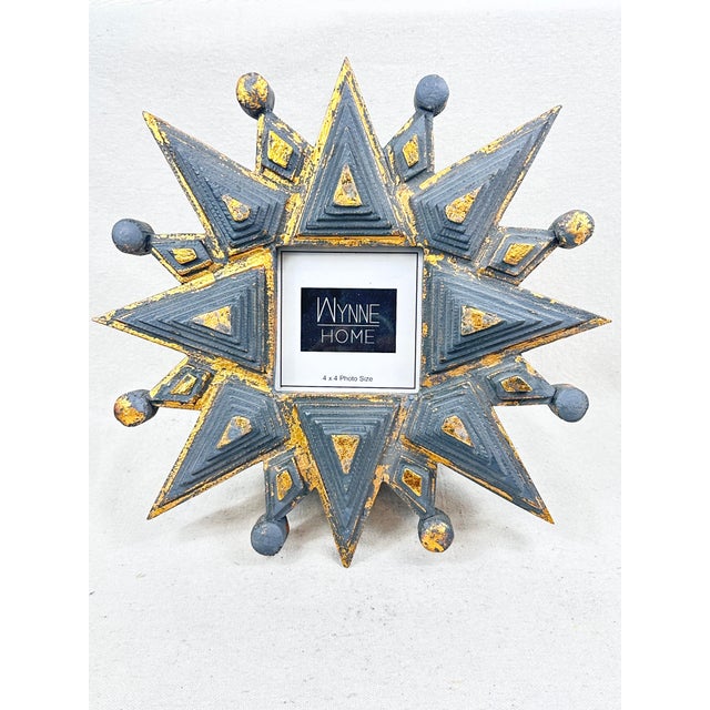 Add a touch of dramatic, celestial charm to your tabletop or gallery wall with this striking starburst photo frame by...