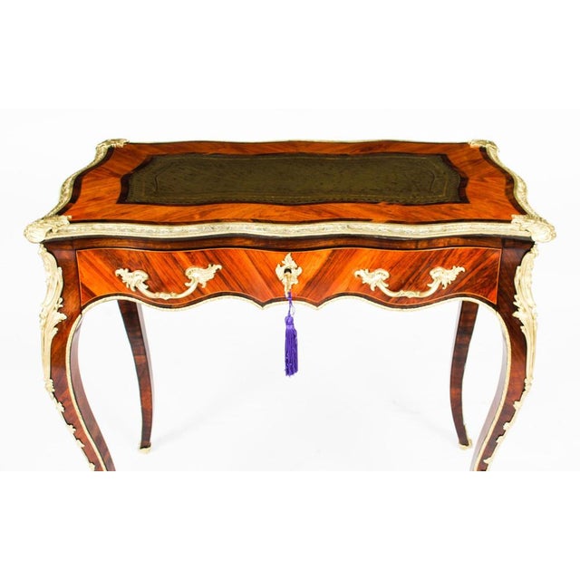 This is an fine and beautiful petite French Louis XV Revival goncalo alves and ormolu mounted bureau plat, circa 1850 in...