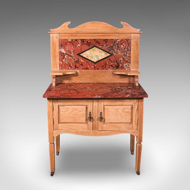 This is an antique washstand. An English, pine and faux marble gallery back dressing table, dating to the Edwardian...