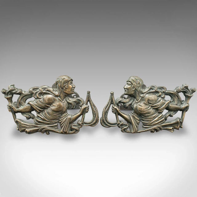 This is a pair of antique figural andirons. A French, bronze decorative fireside tool rest with female form in country...