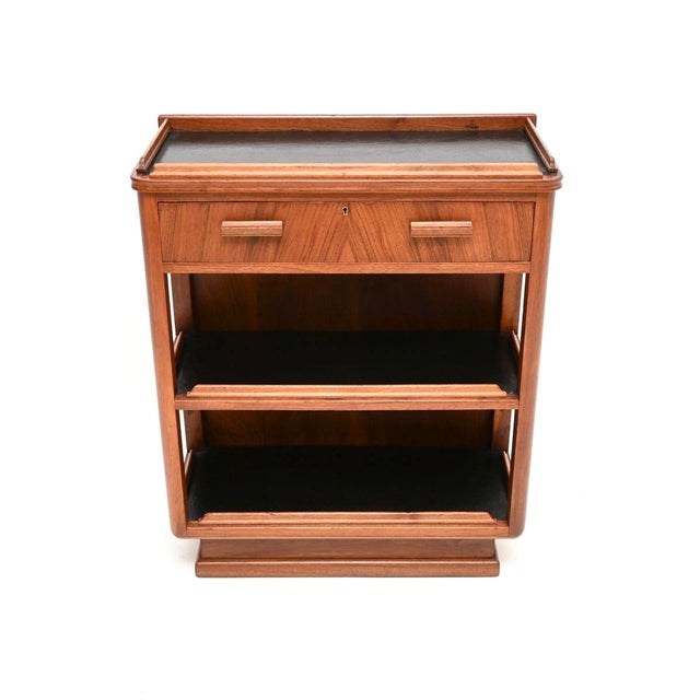 A beautiful and very striking Art Deco walnut and leather bookcase / console table by Waring and Gillows. This was made in...