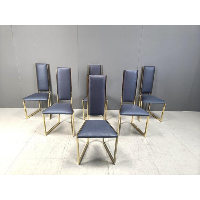 Unique brass dining chairs with a G shaped frame and blue skai/leatherette upholstery. Elegant design, timeless. 1970s -...