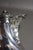 A solid silver coffee pot resting on three hoof-shaped feet with cartouche-shaped brackets decorated with flowers and...