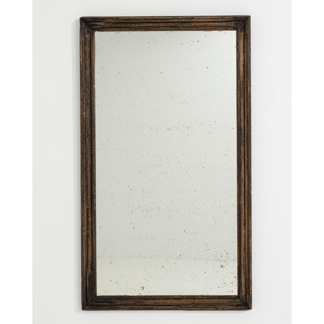A circa 1900 French wall mirror designed in the Louis Philippe style, characterized by its simple form and gently rounded...