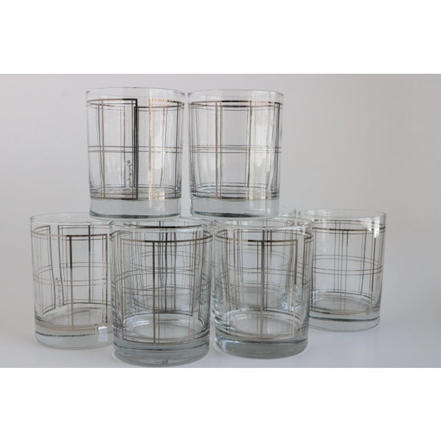 Fabulous set of eight new old stock Georges Briard glasses with wraparound silver tone grid. Like all decorated barware,...