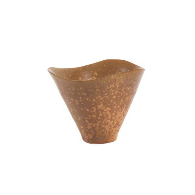 A studio pottery bowl by the American ceramicist Laura Andreson (1902-1999). This speckled brown bowl features a conical...