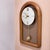 This vintage Elgin wall clock features a distinct mid-century modern aesthetic with a solid wood arched frame and a...