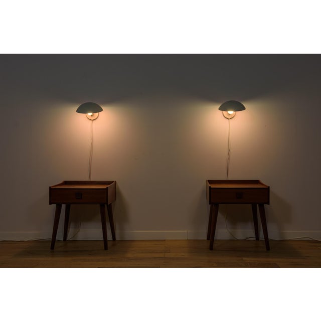 A pair of ph hat wall lamps, designed by poul henningsen for louis poulsen in denmark in 1961, feature an adjustable shade...