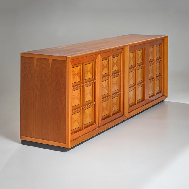 Rectangular sideboard with a clean, linear design and striking decorative details. The four doors feature inlaid square...