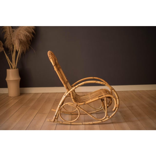 Mid century modern rocker in the style of Franco Albini, circa 1970's. Features woven rattan details and a tall supporting...