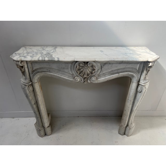 Louis xv style fireplace in white veined carrara marble, italy two curved jambs with sculpted scrollwork sculpted frieze...