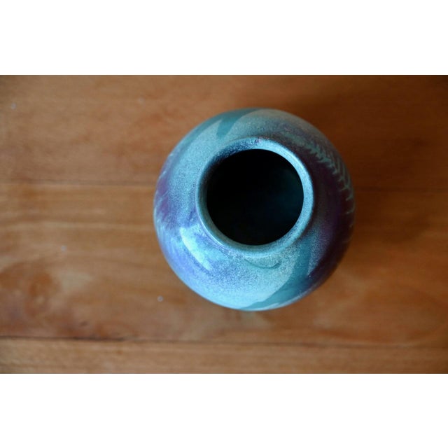 Simple yet precious, this small stoneware spherical vase tells the story of a potter passionate about his craft. Its soft,...