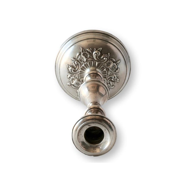 A sterling silver candlestick by Gorham in Pattern 987, featuring a baluster column and ornate floral repoussé base....